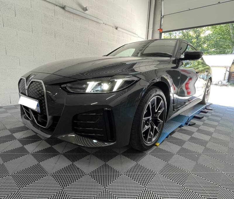 Application du traitement céramique professionnel sur la carrosserie d'une BMW i4 Individual dans notre centre de detailing à Fleurieu-sur-Saône.